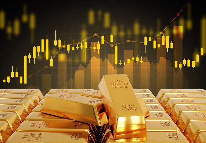 Gold bars stacked before a glowing market chart on a dark background