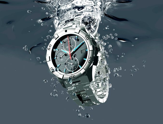 Silver watch splashing through water, with bubbles and a dark blue background
