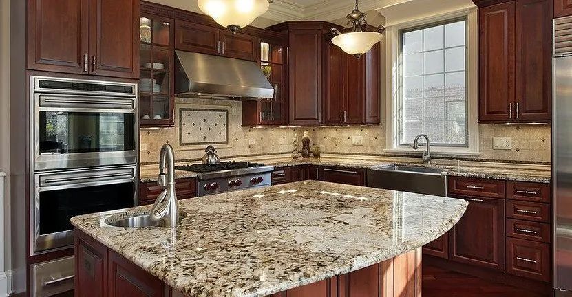 Kitchen with dark wood cabinets, granite countertops, and stainless steel appliances.