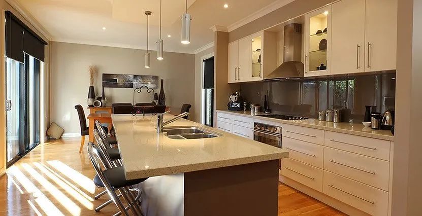 Modern kitchen with island, cabinets, appliances, and hardwood floors.