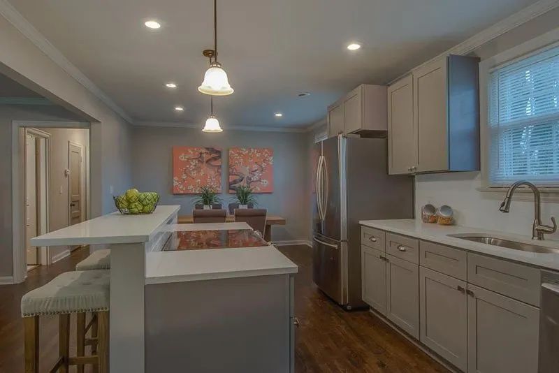 Kitchen with light gray cabinets, stainless steel appliances, and a breakfast bar.