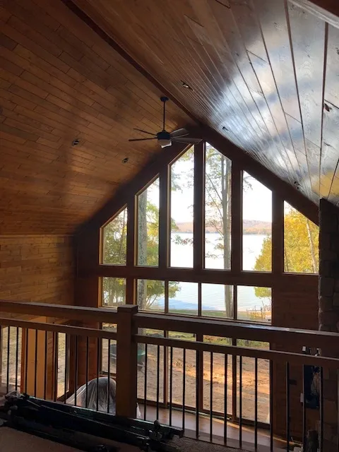 a room with a lot of windows and a ceiling fan