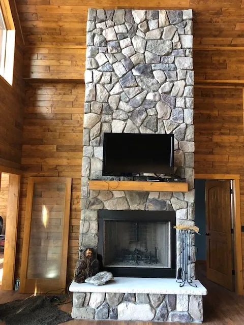 a large stone fireplace with a flat screen tv mounted on it