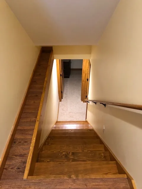 a set of wooden stairs leading up to a basement in a house