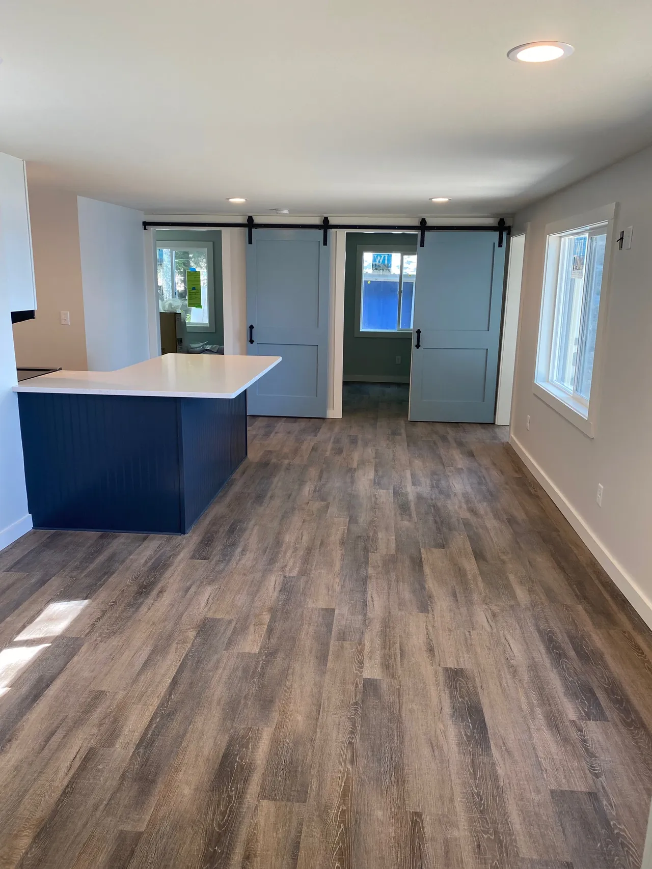 a living room with a blue island and sliding barn doors