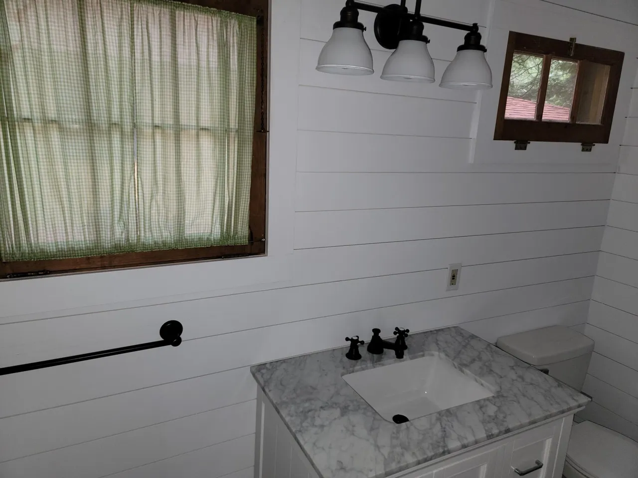 a bathroom with a sink a toilet and a window