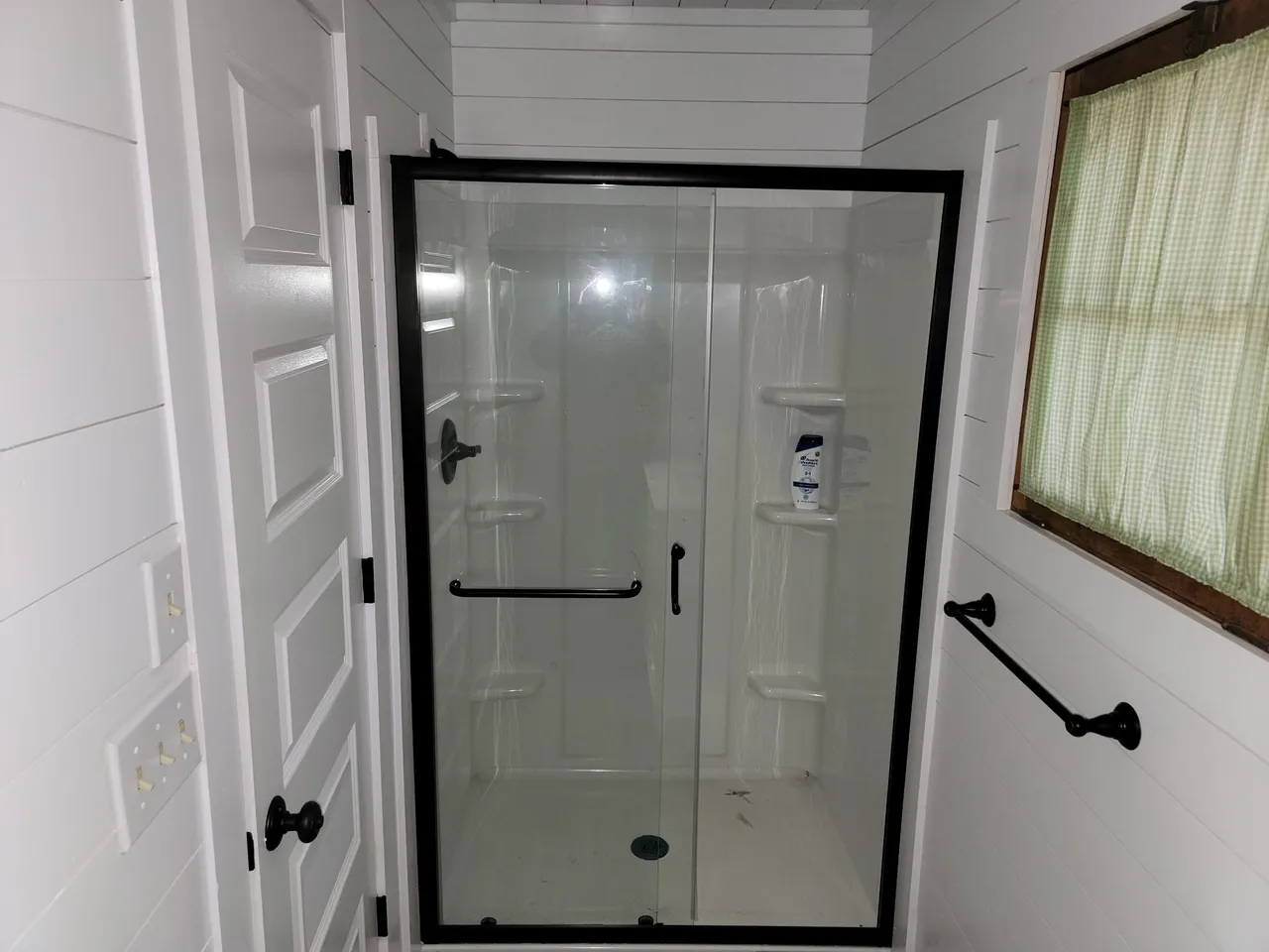 a bathroom with a walk in shower and a window