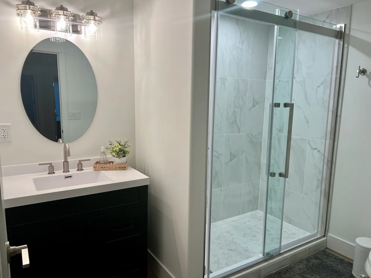 a bathroom with a sink , toilet , shower and mirror .