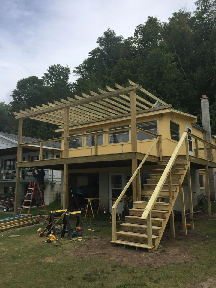a house with a wooden deck and stairs under construction