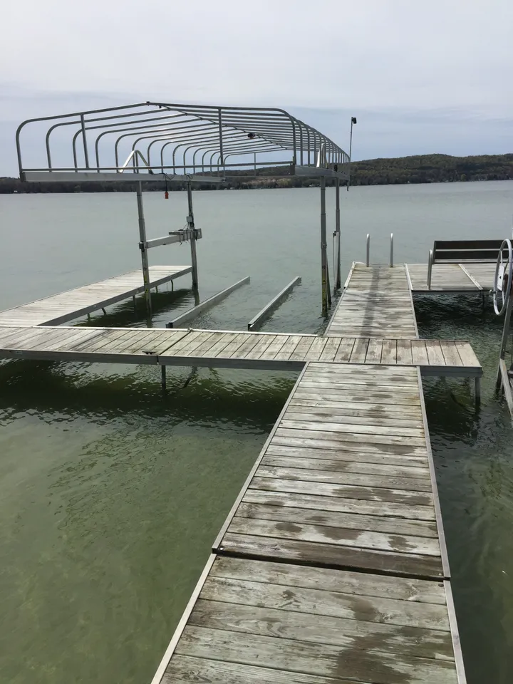 a wooden dock with a metal structure overlooking a body of water