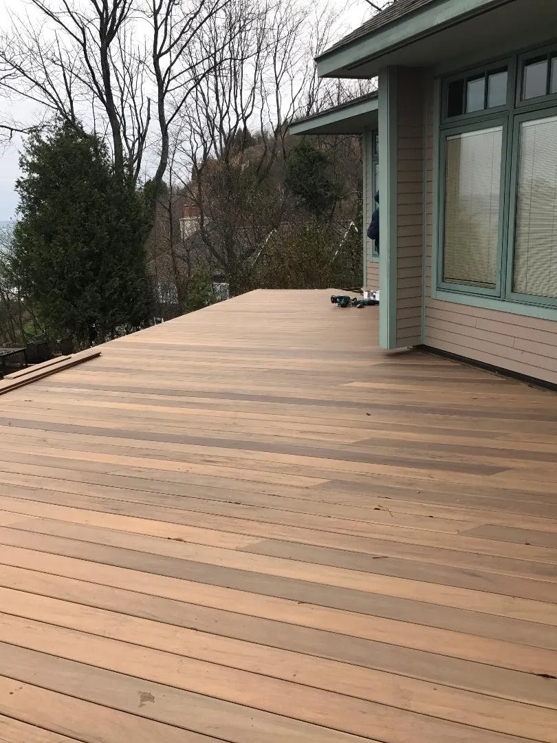 there is a large wooden deck in front of a house