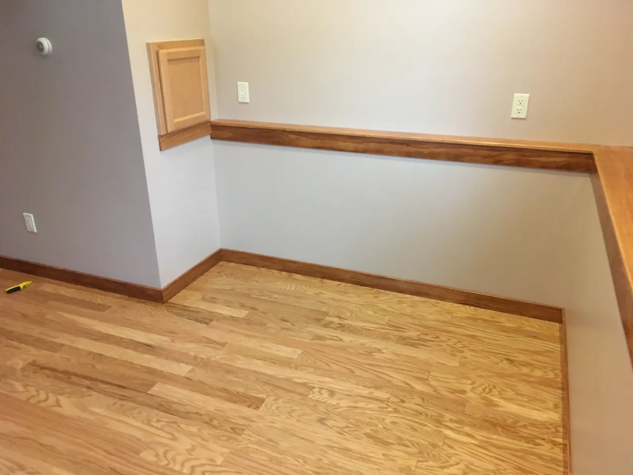a room with hardwood floors and a gray wall