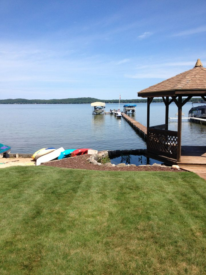 a gazebo overlooking a lake with boats docked at the dock