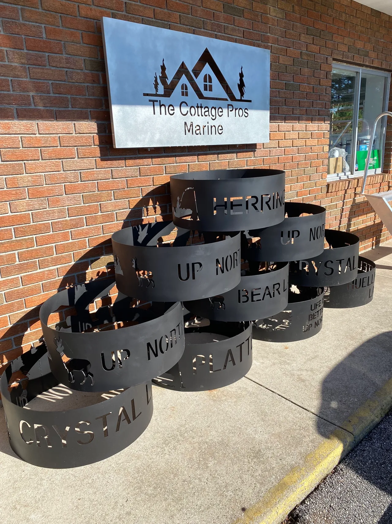 a stack of fire pits are sitting on the sidewalk in front of a brick building