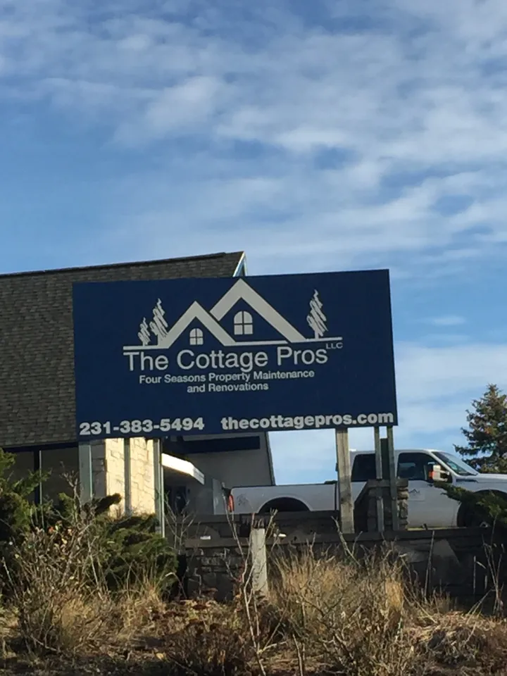 a billboard for the cottage pros is in front of a house