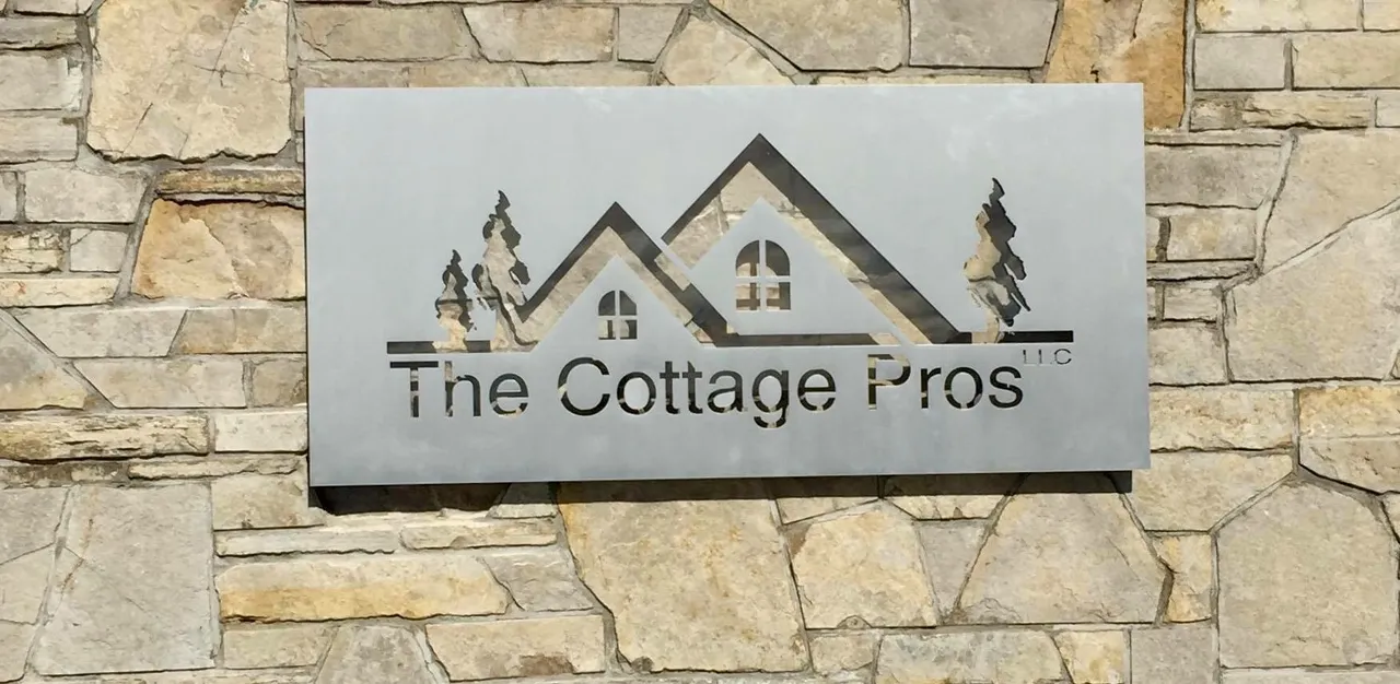 a sign on a stone wall that says the cottage pros