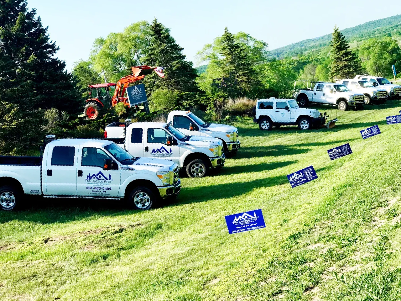a row of trucks are parked on a grassy hillside