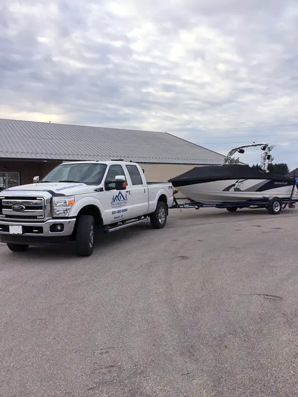 a white truck is pulling a boat on a trailer