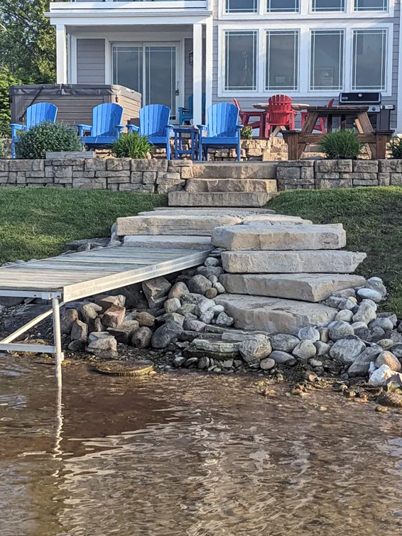 a dock with stairs leading to a house next to a body of water