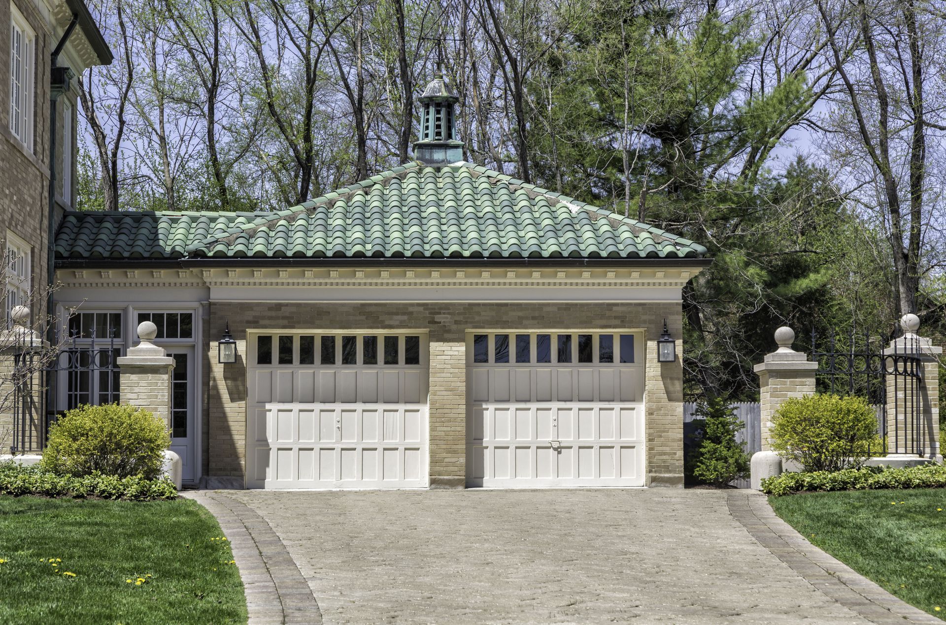 A house with two garage doors and a green tiled roof
