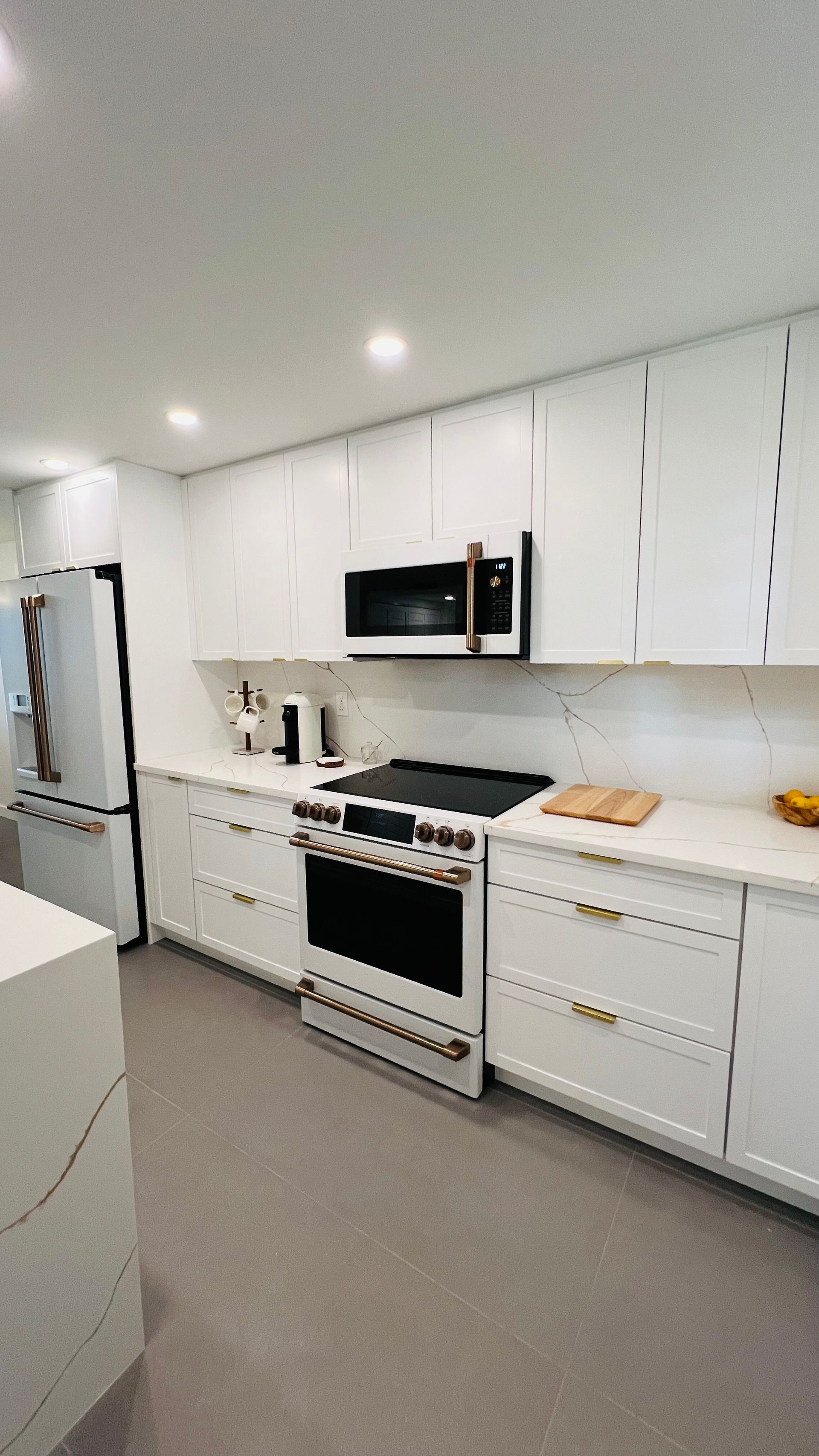 A modern kitchen featuring white cabinets, stainless steel appliances, and a light-colored countertop.