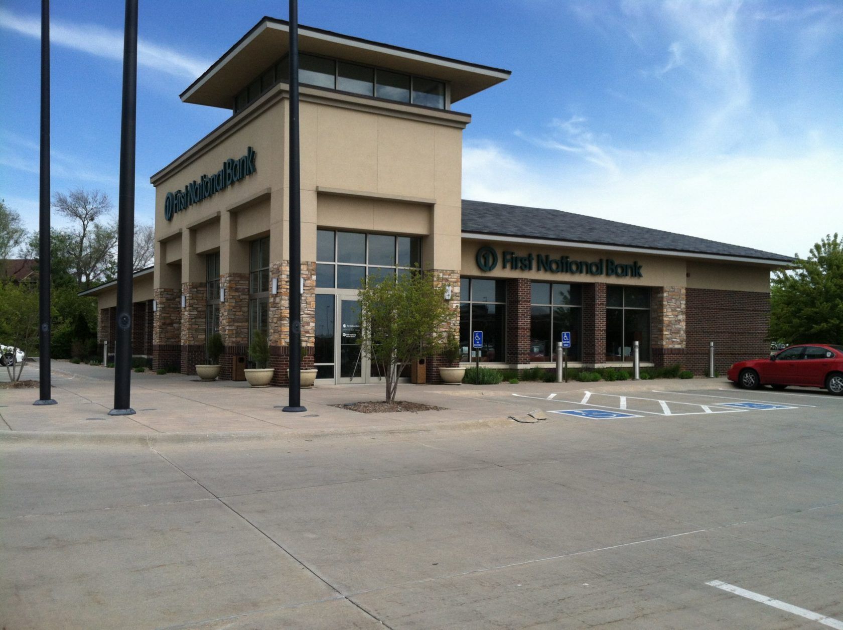 A first national bank building with a red car parked in front of it