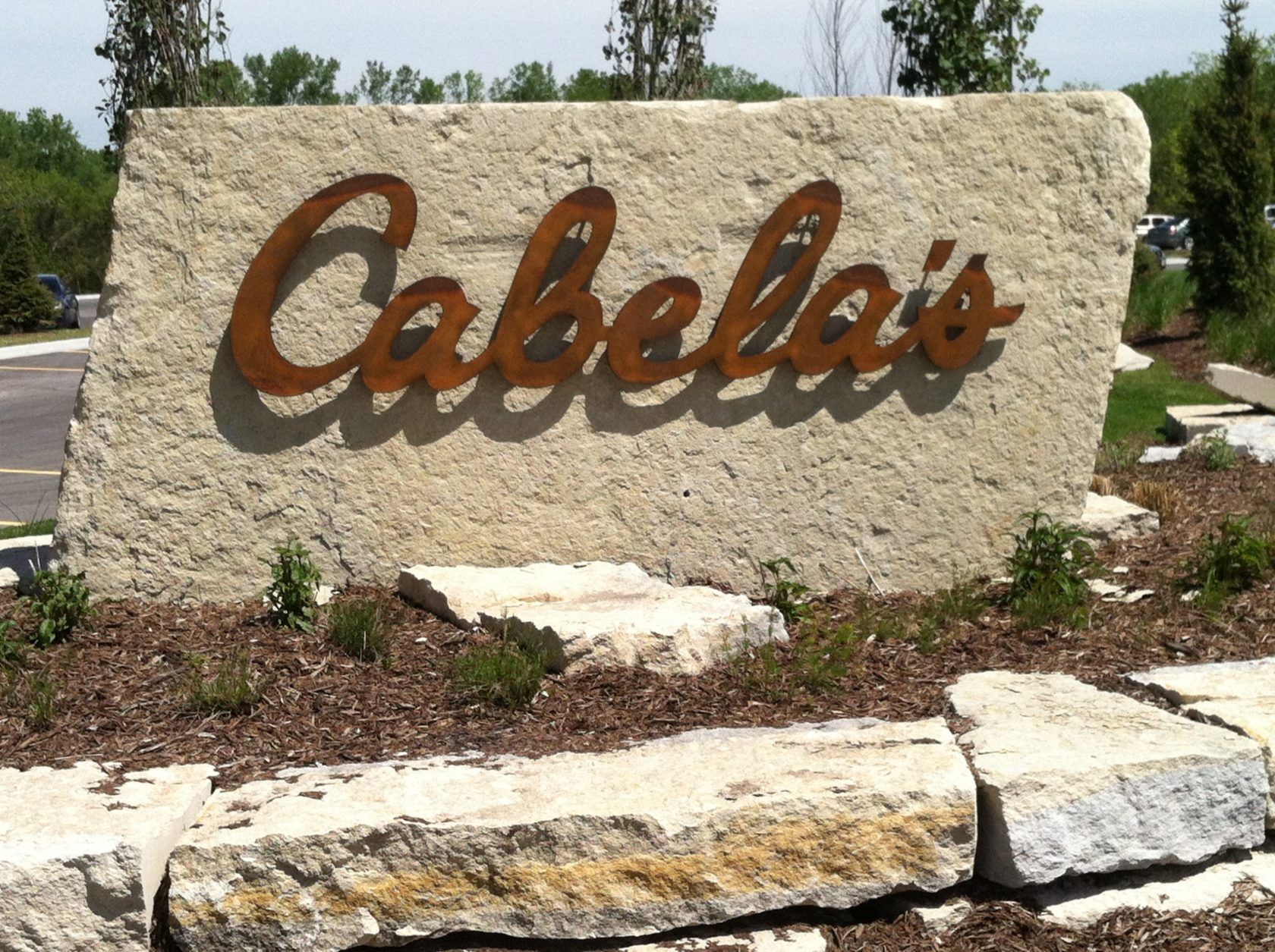 A large stone sign that says cabela 's on it