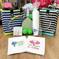 A paddle ball set and bags are sitting on top of a wooden table.