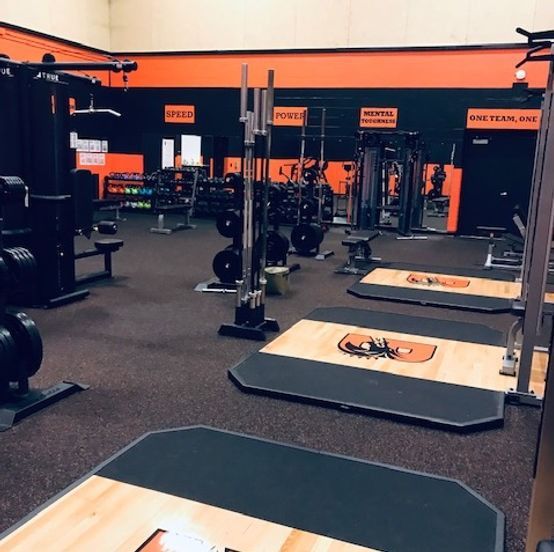 A gym with a lot of equipment and a sign that says ' fitness ' on it