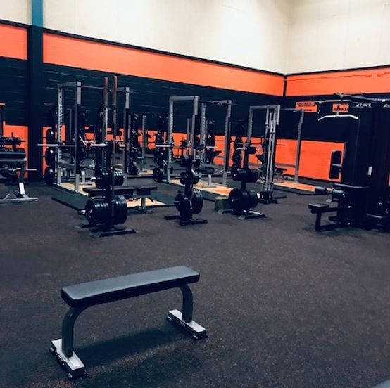 An empty gym with a bench in the middle