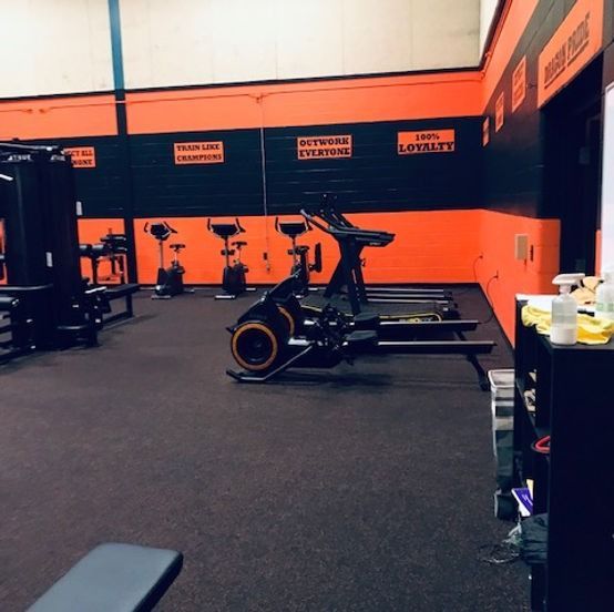 A gym with orange walls and a sign that says lots left