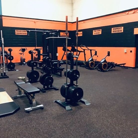 A gym with a sign on the wall that says expect success