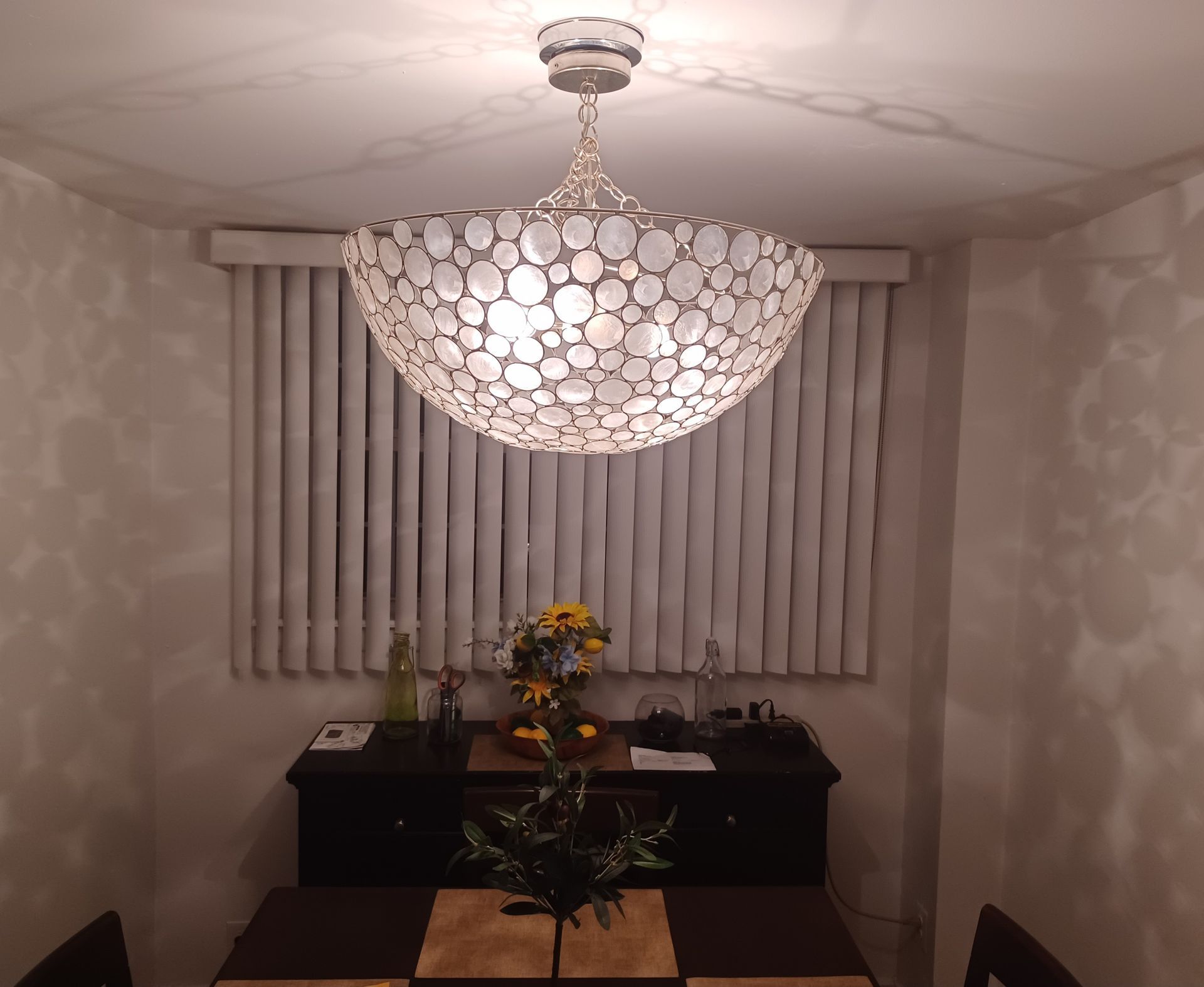 A dining room with a large chandelier hanging from the ceiling.