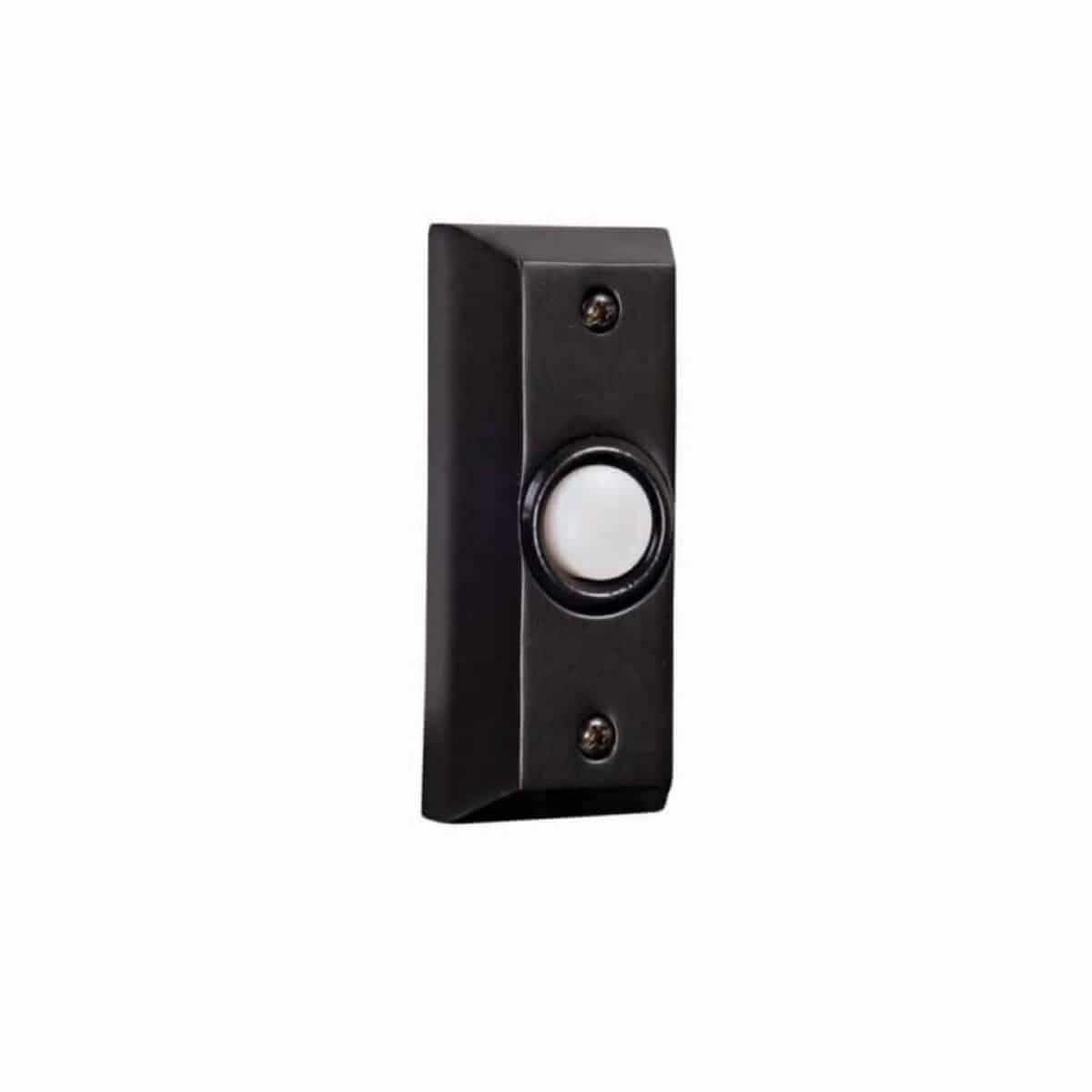 Black rectangular doorbell with a white button, mounted on a wall. Two screws secure it.