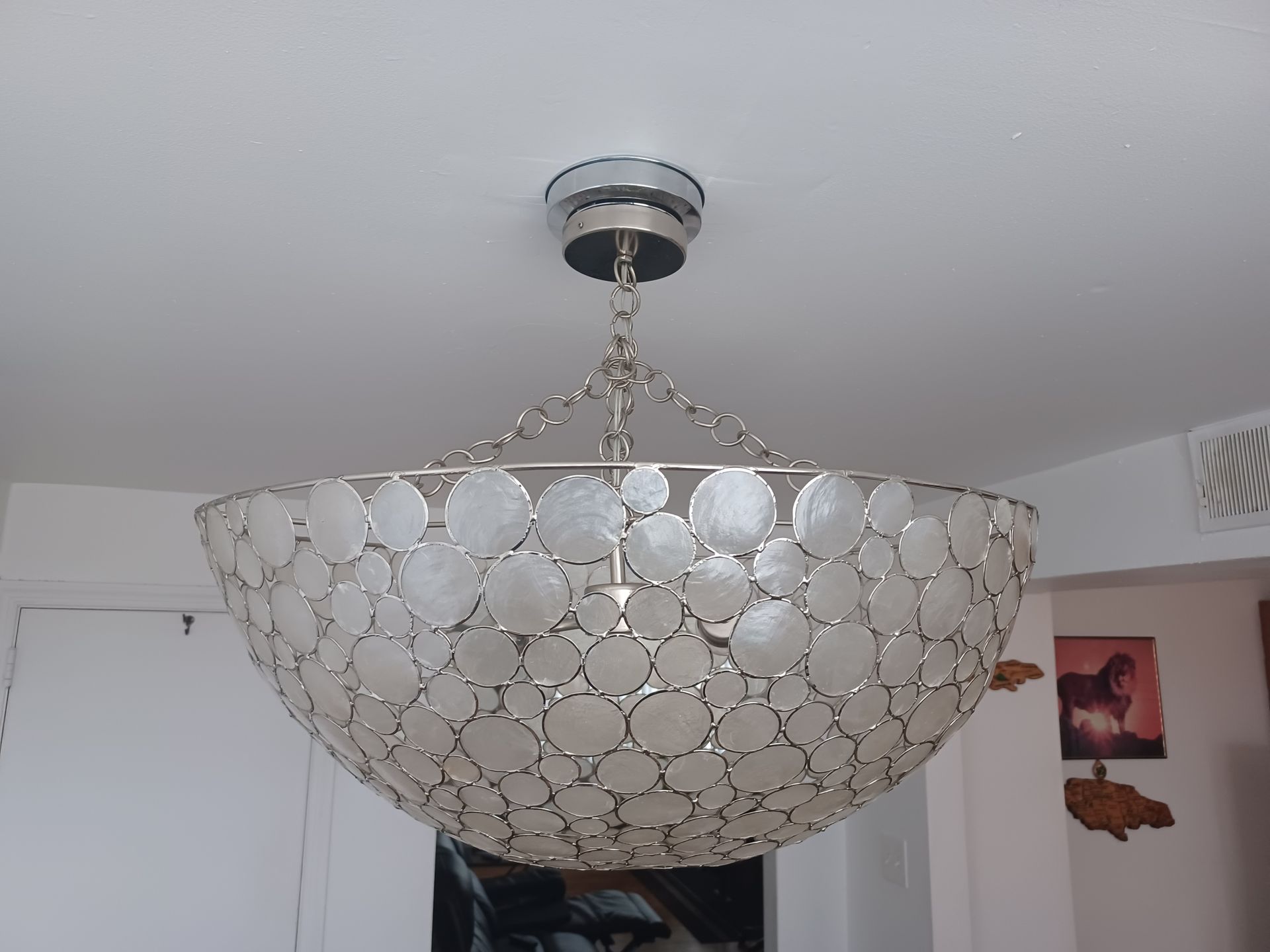 A chandelier made of seashells hangs from the ceiling