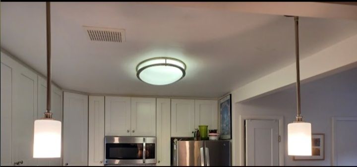 A kitchen with two pendant lights hanging from the ceiling