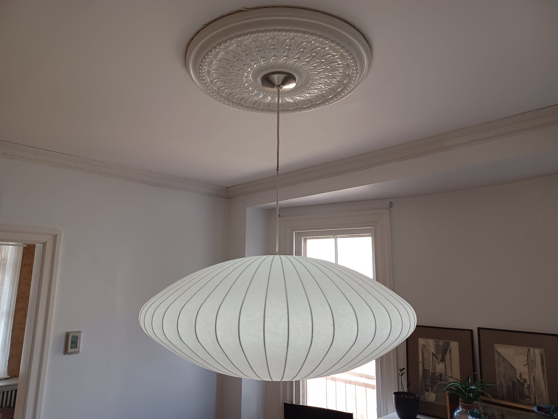 A white lamp hanging from the ceiling in a room
