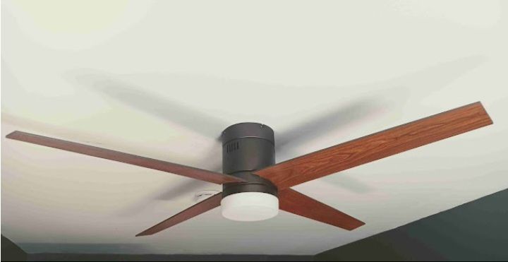 A ceiling fan with wooden blades is hanging from the ceiling of a room.