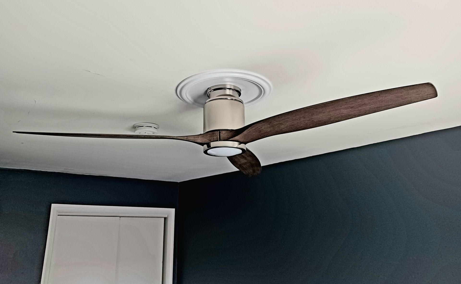 A ceiling fan is hanging from the ceiling in a room.