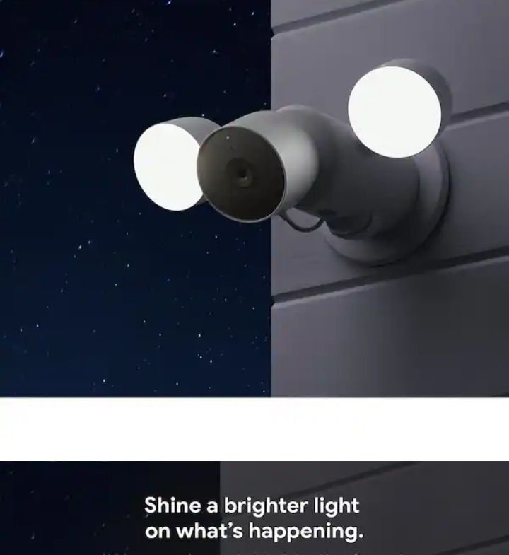 Three-lens outdoor security camera with bright white lights on a wall at night