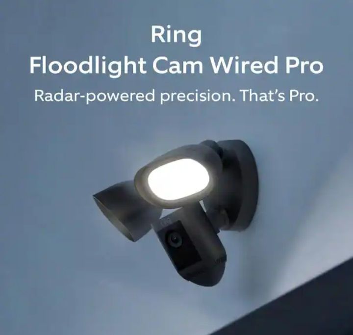 Ring Floodlight Cam Wired Pro on a wall, bright dual floodlights aimed outward.