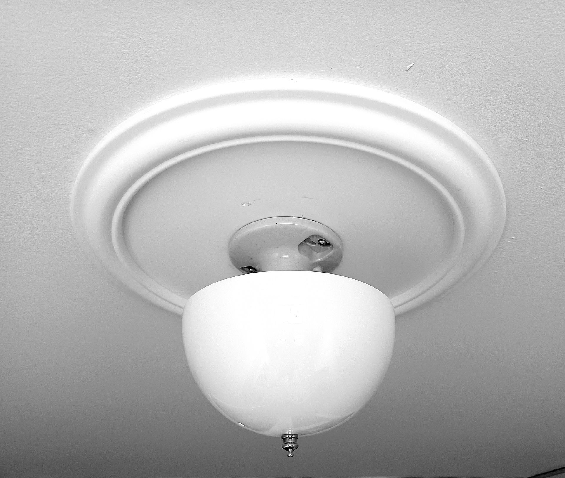 White ceiling light fixture with frosted glass globe and decorative round canopy