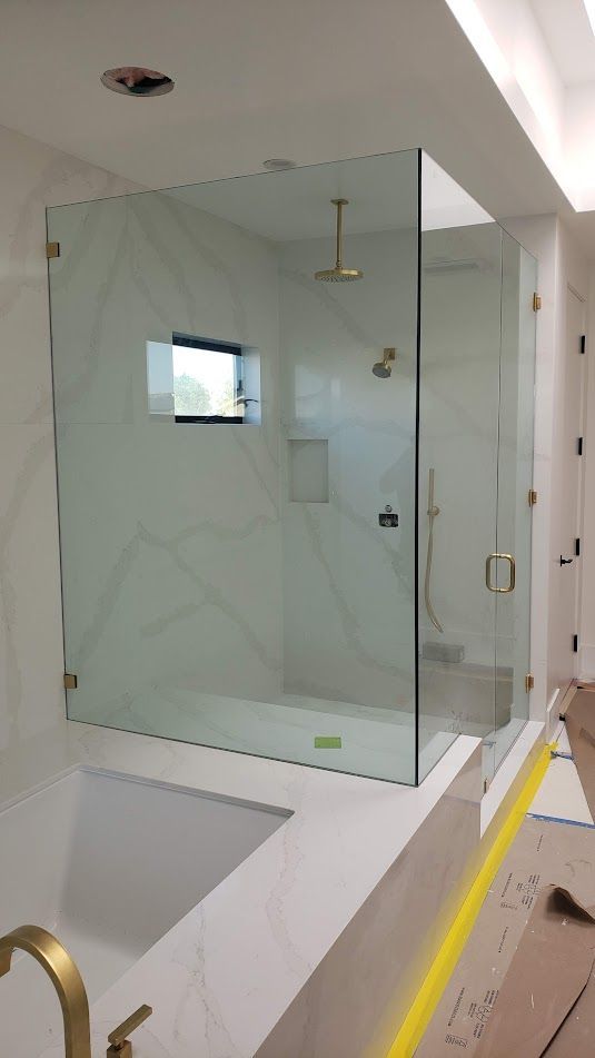 A bathroom with a walk in shower and a bathtub.