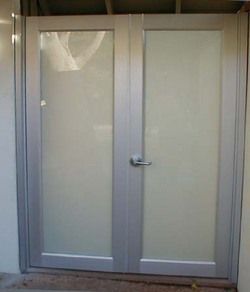 A white door with a handle is sitting in a room.