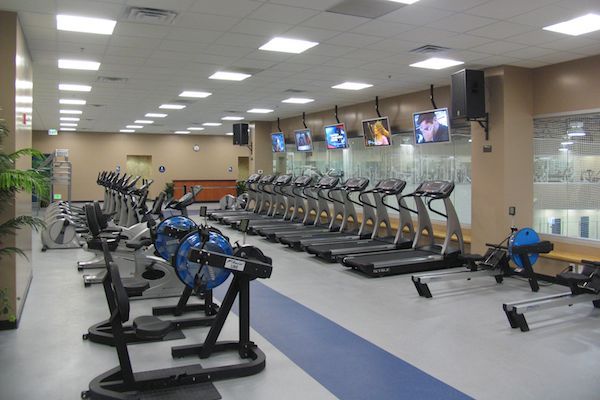 A gym with a lot of treadmills and exercise bikes