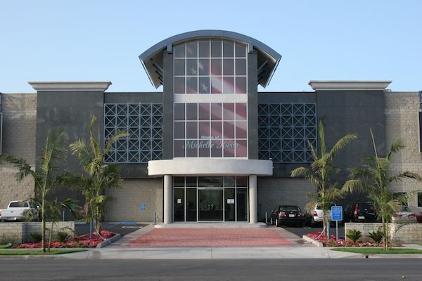 A large building with a lot of windows and palm trees in front of it