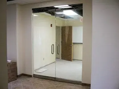 An empty room with sliding glass doors and a white board.