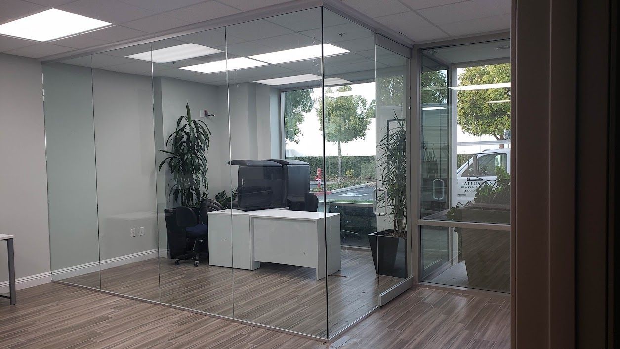 A room with a glass wall and a desk in it.