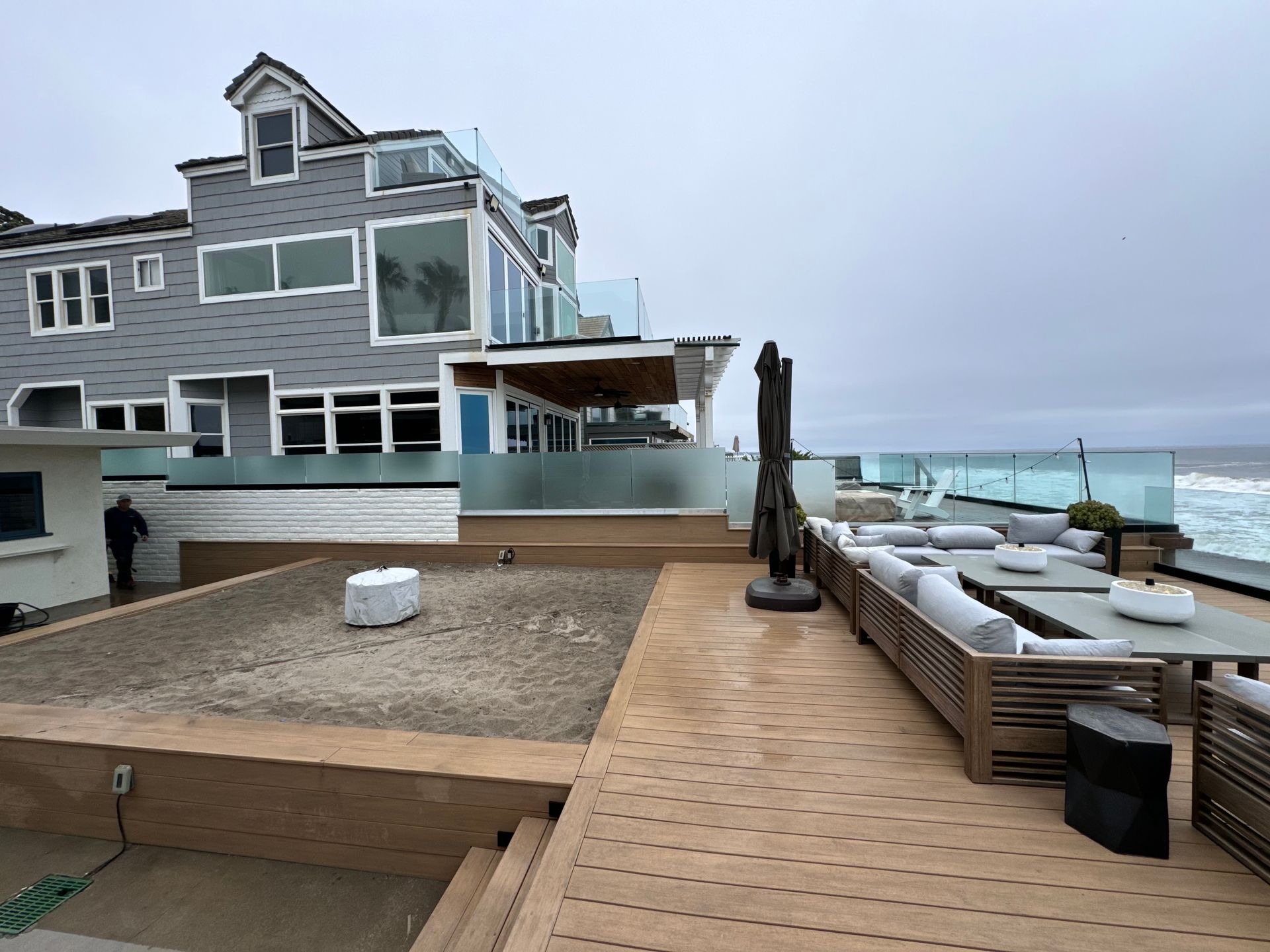 Coastal home with outdoor deck and ocean view on a cloudy day.