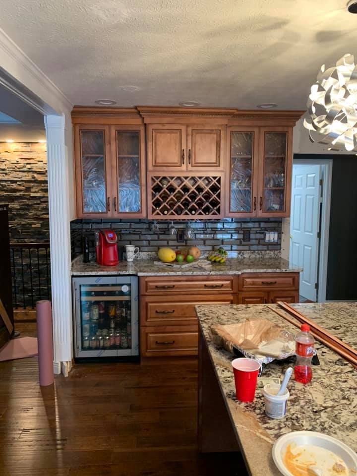 a kitchen with wooden cabinets , granite counter tops , and a wine rack .